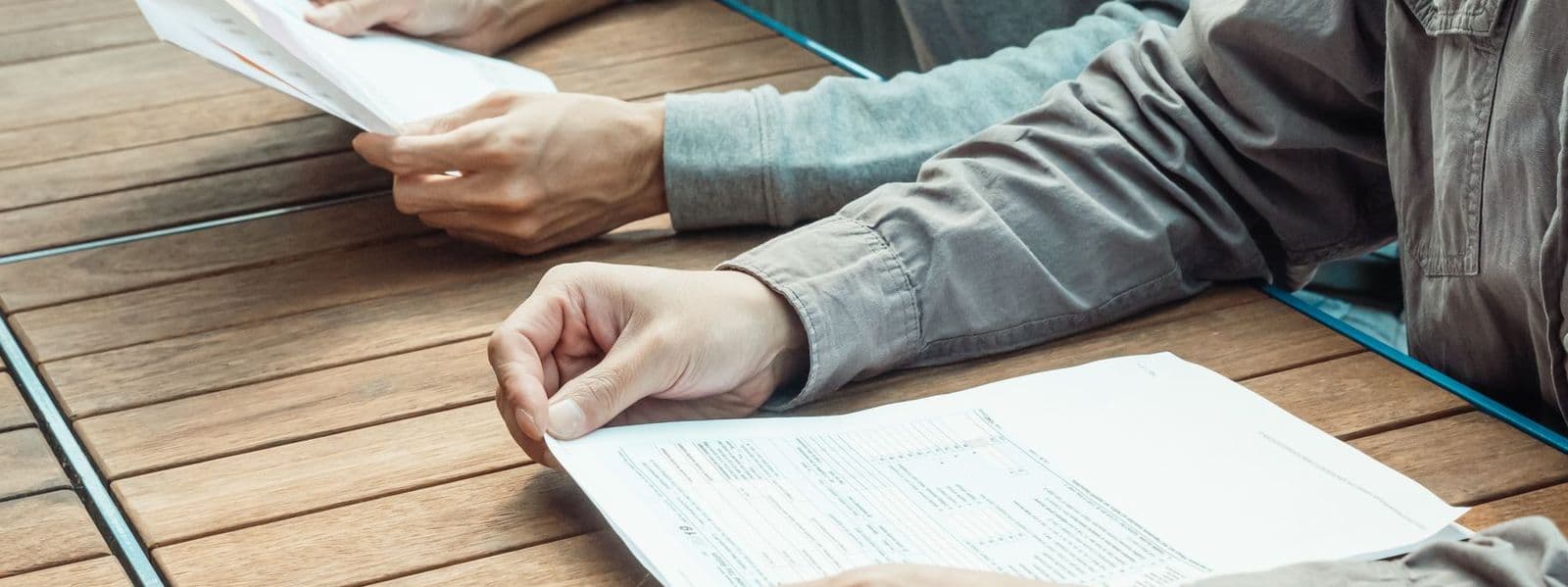Hands going through paperwork at a table