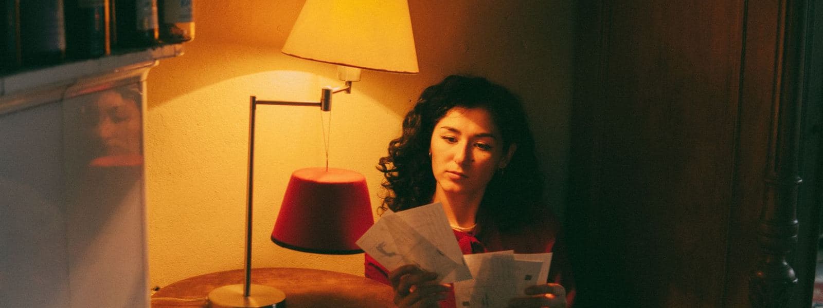 Someone reading a letter at home under a lamp