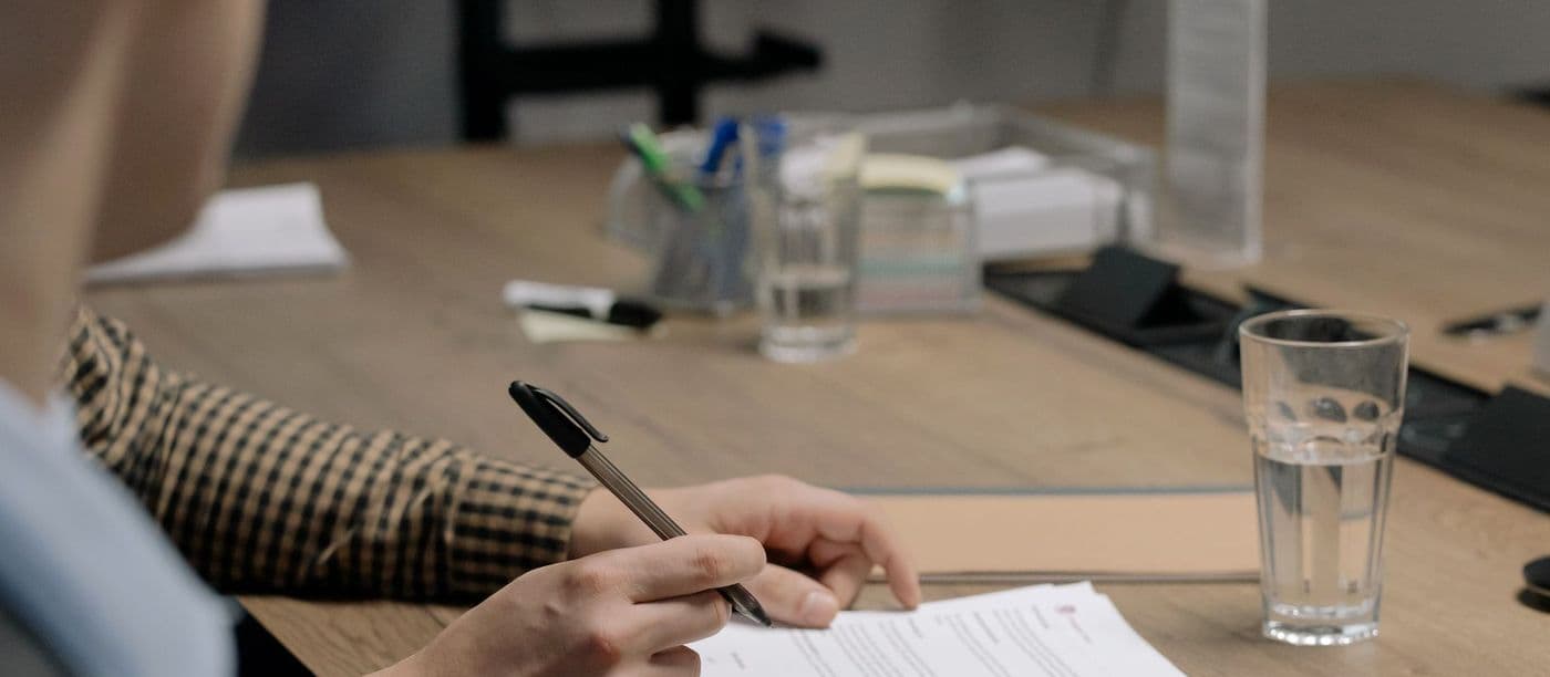 Someone signing a document at a desk
